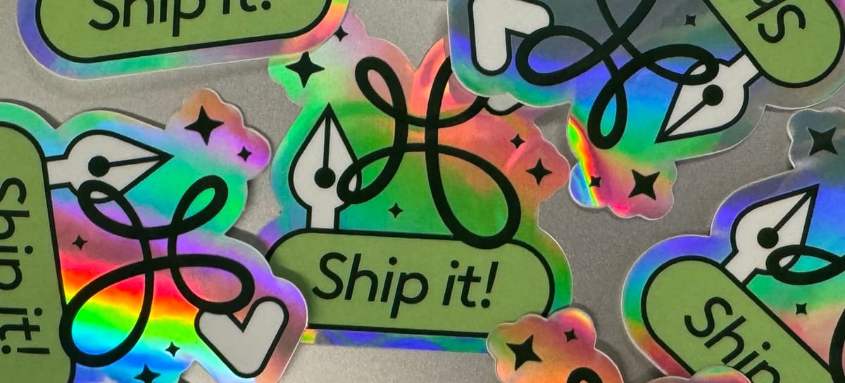 Holographic "Ship it!" stickers scattered across a table